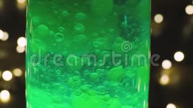 熔岩灯复古嬉皮抽象背景，绿色蜡移动漂浮。 背景中花环的波克