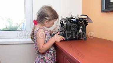 可爱的小女孩在老式打字机上写字。 学前观念，童年观念.. 像学龄前儿童这样可爱的女孩