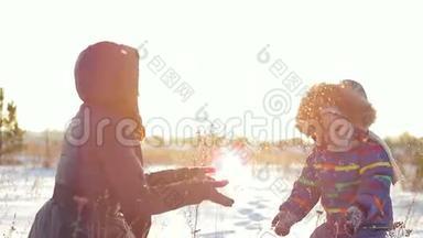 快乐的女人和孩子在日落时玩雪