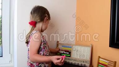 可爱的小女孩玩算盘，用粉笔<strong>在黑板上写字</strong>.. 学前观念，童年观念.. 玩具