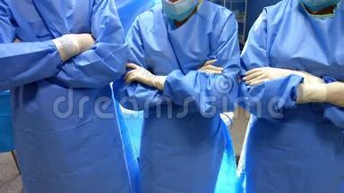 手术间交叉双臂站立的外科医生和护士的画像