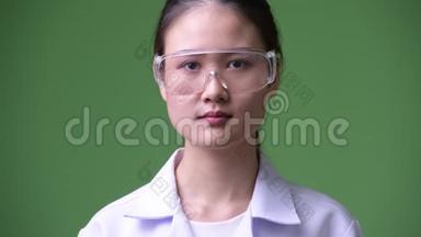 年轻漂亮的亚洲女医生戴着防护眼镜微笑