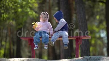 坐在长凳上吃香蕉的<strong>两个小孩子</strong>