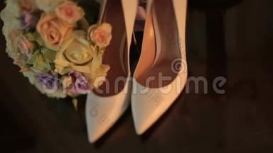 奢华的白皮<strong>女高跟鞋</strong>摆在餐桌旁华丽多彩的婚礼花束。