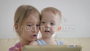 可爱的弟弟妹妹使用数字平板电脑，微笑着，看上去很<strong>开心</strong>。 兄弟姐妹玩得<strong>开心</strong>