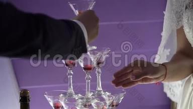 人们用香槟<strong>把酒</strong>倒进金字塔形的玻璃杯里