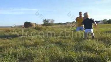在阳光明媚的日子里，<strong>小孩</strong>子在田野上给他的父亲吃青草。 快乐的一家人在<strong>夏天</strong>的草地上。 快乐宝贝