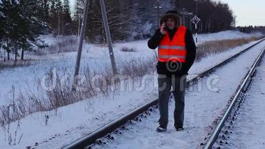 铁路<strong>员工</strong>冬天在铁路上<strong>使用</strong>智能手机
