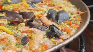 西班牙海鲜饭和<strong>黄米</strong>饭，虾和贻贝在食品市场上烹饪。 街头美食节。 海鲜饭
