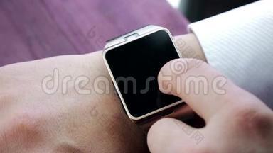 使用智能手表应用程序的人用手指在木桌上