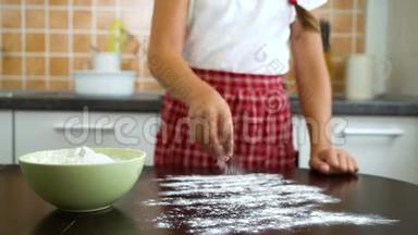 将年轻女孩的手准备好工作表面，用于面团揉搓，在黑暗的桌子上铺面粉