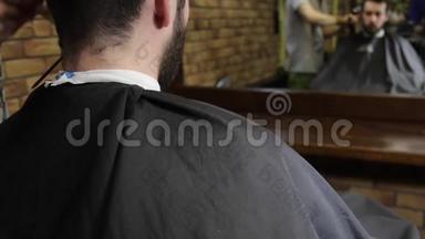 理发师用理发工具剪了客户黑发<strong>男子</strong>的<strong>头发</strong>。