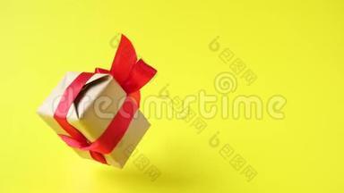 礼品盒，红色丝带在黄色背景上旋转。 <strong>360</strong>度旋转。 零重力。 悬浮。 共空间。 概念销售d