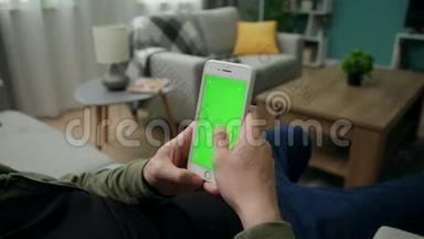 男人在家坐在沙发上用智能手机加绿色锁屏