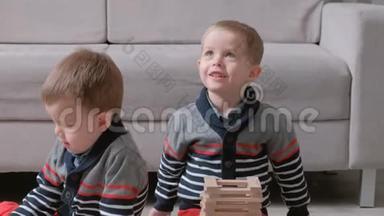 <strong>双胞胎兄弟</strong>正在用坐在他们房间沙发旁的木头积木搭建。
