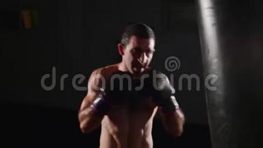 拳击手在拳击袋上打拳。 室内战斗机训练