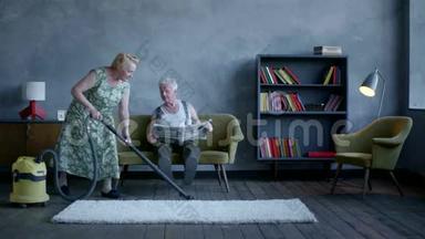 一位老年妇女用吸尘器清理地板，一位老年男子正在看报纸