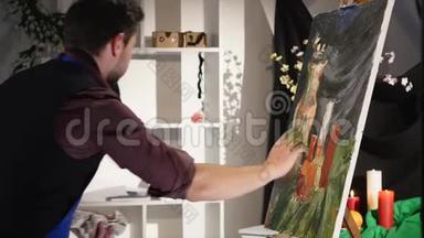 用油画画架画这位艺术家. 这位现代艺术家在画布上用油画他的画。 的肖像