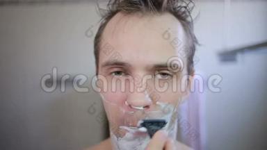 他在浴室里用剃刀刮胡子