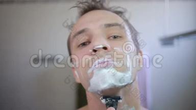 他在浴室里用剃刀刮胡子