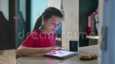 少女正在吃三明治，在平板电脑上玩一个网络游戏。 女孩社交媒体平板电脑互联网