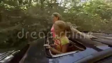 两个快乐的金发女郎笑着从汽车的舱口跳出来，向森林边走去