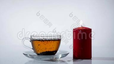 茶杯，白色背景上点燃红色蜡烛
