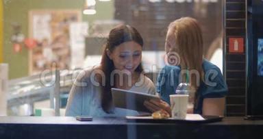 女朋友在咖啡馆里聊天和使用触摸板