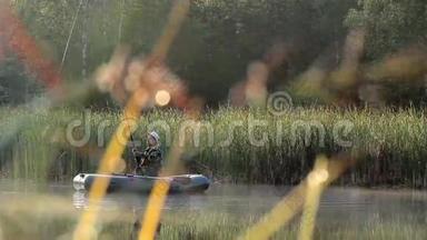 渔夫乘一艘<strong>充气船</strong>在河上漂浮。 太阳的光线在镜框里播放。 野外活动