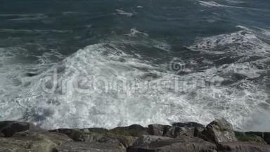一个美丽的海洋沙滩与蓝色的波浪滚动到海岸，一些岩石呈现。