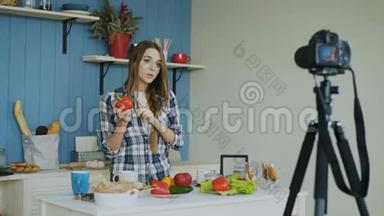 在厨房的dslr摄像头上，一位开朗、有魅力的视频博客上<strong>录制</strong>素食健康食品