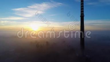 日出时高高的未使用的烟囱在晨雾上方-空中镜头，令人惊叹的光。