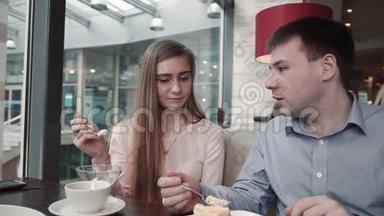 漂亮的年轻夫妇在<strong>咖啡</strong>馆里使用智能手机看着<strong>展示</strong>微笑