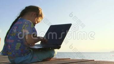 小女孩在海边玩电脑
