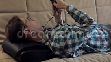 男人躺在家里的沙发上，躺在按摩器的头下，放松的状态