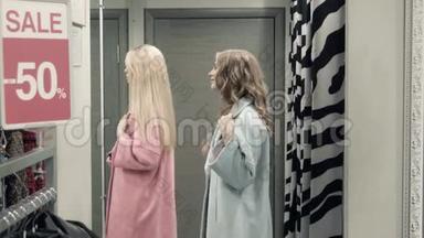 两个女孩在更衣室里试穿外套