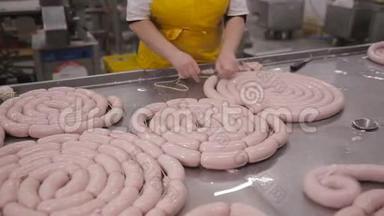 在自动化肉类加工设备上制作香肠、肉类美味的工人。