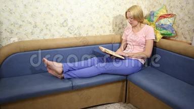 年轻女子坐在沙发上看书