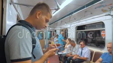休闲旅行者男子从手机智能手机屏幕上阅读，同时看导航员在地铁上旅行