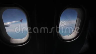 透过飞机的窗户观看蓝天和云彩，用飞机的翅膀关闭飞机的窗户