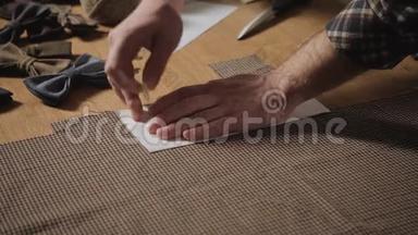 剪羊毛织物。 线条图案。 羊毛织物的蝴蝶结。 做裁缝用缝纫的年轻人
