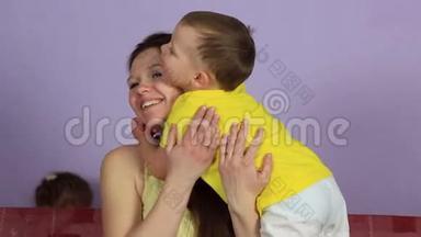 小快乐的宝宝拥抱亲吻快乐的妈妈。