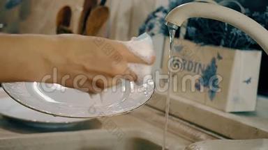 女人正在厨房里用肥皂洗碗。 带有侧面<strong>摄像机运动</strong>的特写镜头