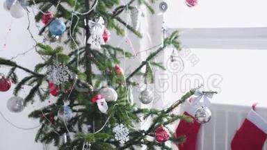 时尚的白色圣诞内部装饰杉树，袜子，蜡烛，花环靠窗