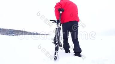 一个骑着山<strong>地</strong>车的人。 比克正在雪<strong>地</strong>里<strong>推</strong>自行车。 多云的冬日，风和雪花轻柔