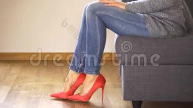 穿着红色高跟鞋坐在沙发上的女人展示和交叉，<strong>修长</strong>的腿