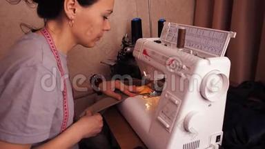 缝纫机上的裁缝工作。 女孩坐在桌子旁，在缝纫机上涂鸦。