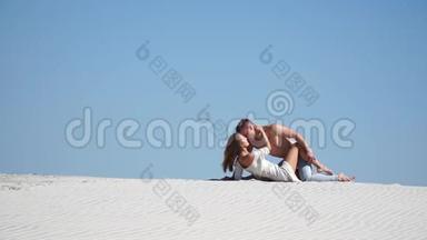一个强壮的男人和一个美丽的女孩躺在沙漠的沙滩上