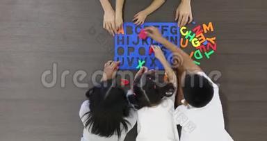 亚洲老师和学生<strong>一起</strong>玩彩色字母<strong>拼</strong>图玩具，游戏时间概念。