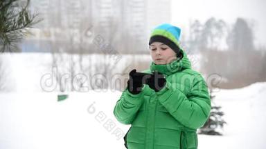 冬天男孩在外面戴手套用手机